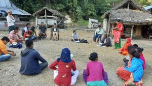 group of men and women sitting on grass field in a circle discussing