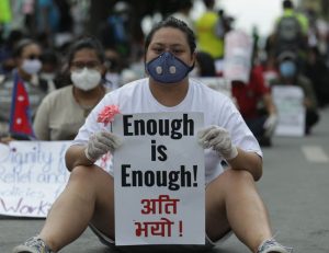 lady protesting with a signboard for enough is enough movement in nepal