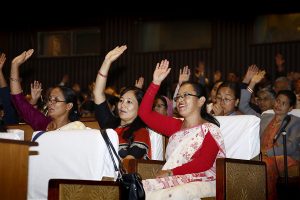 women in saree raising hands